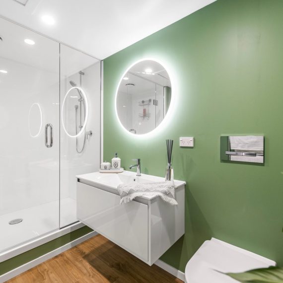 Sleek bathroom design with a large shower enclosure, wall-hung vanity, and contemporary LED mirror